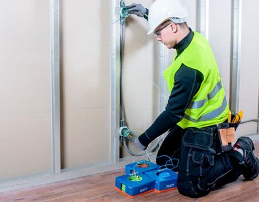 Installer laying cable in wall